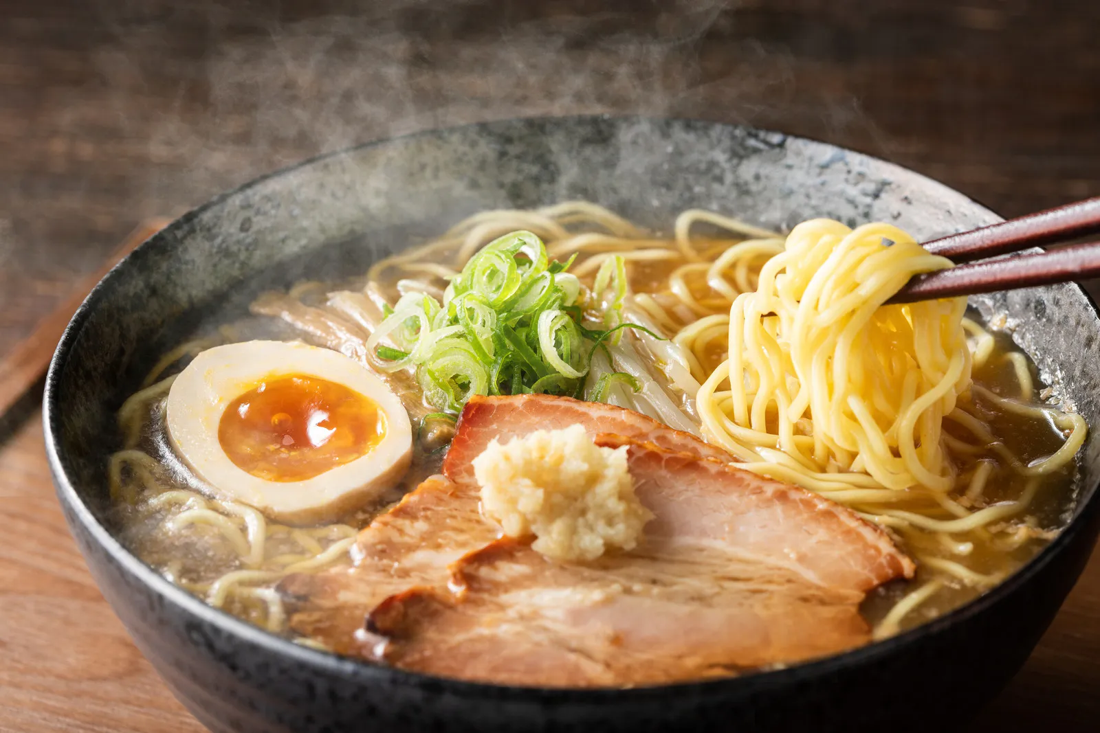 Steaming bowl of ramen with chashu pork, soft-boiled egg, and scallions at Sumo Ramen CO, a Chinese Restaurant in Fayetteville