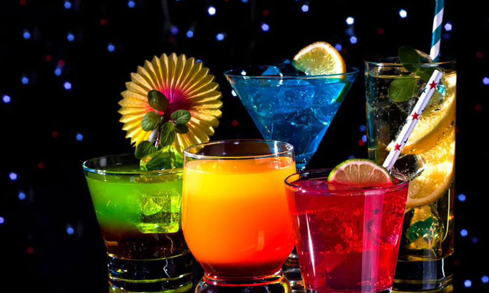 Colorful signature cocktails in various glasses against a dark background at Sumo Ramen CO, a Chinese Restaurant in Fayetteville